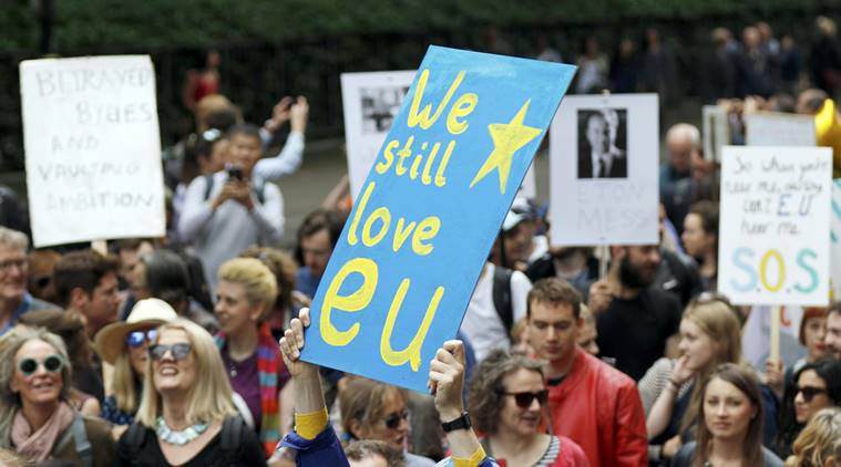 People hold banners during a demonstration against Britain's decision in BREXIT